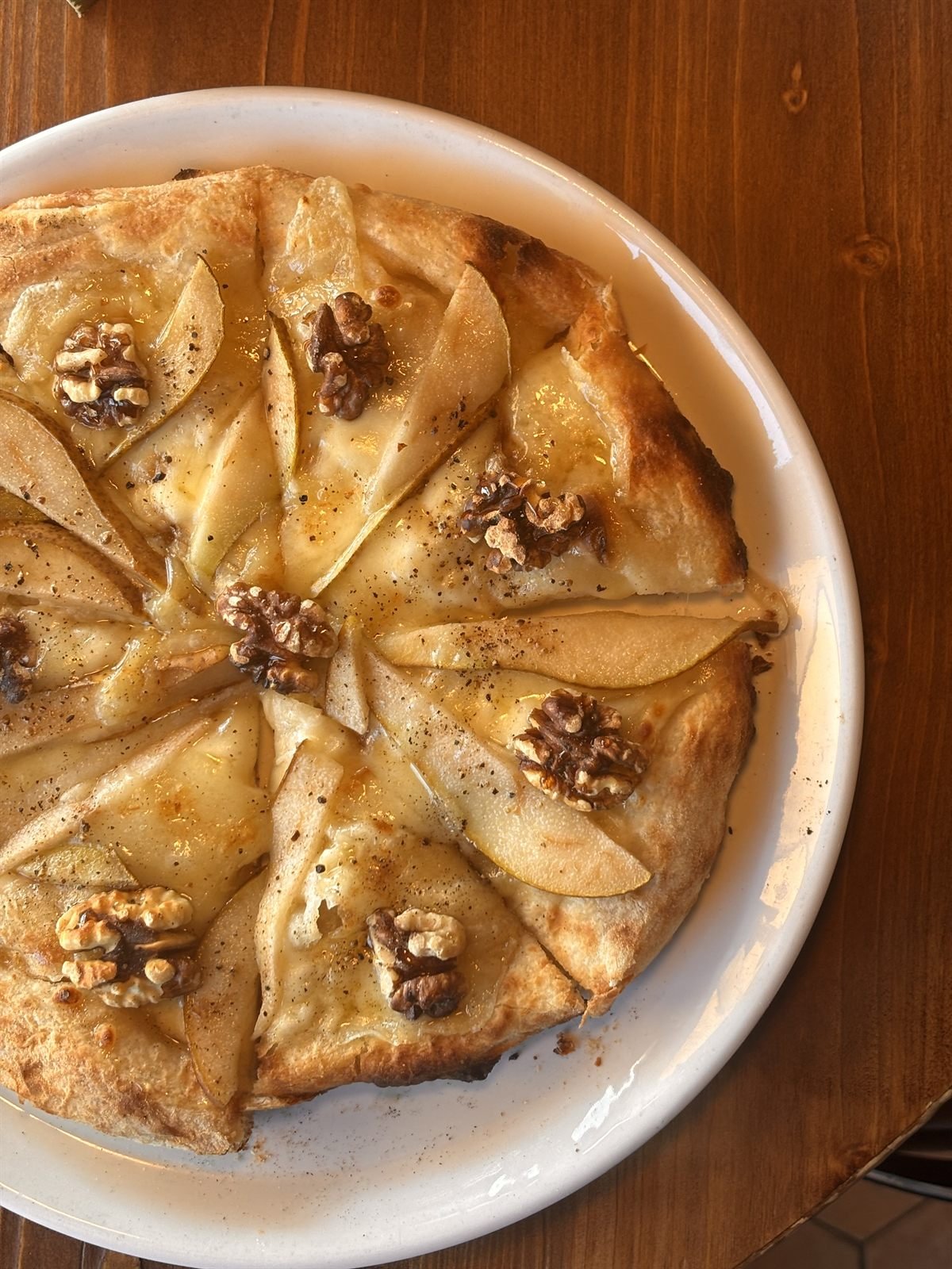 Pinsa with pear, melted cheese, walnuts and honey