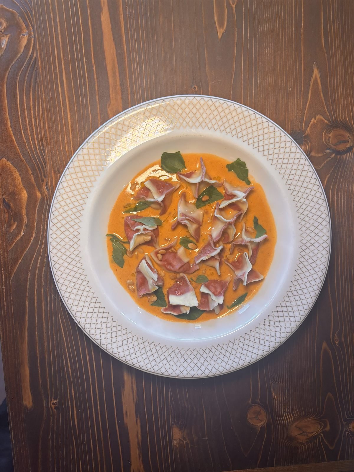 Hand-made ravioli in a tomato cream with basil and pine nuts
